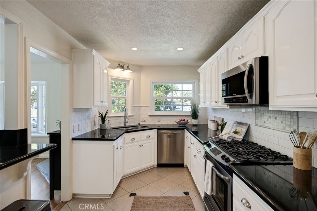 4914 Halison Street Torrance, CA 90503 - Photo 22 of 51 a kitchen with stainless steel appliances a sink dishwasher a stove top oven a sink with wooden floor and cabinets