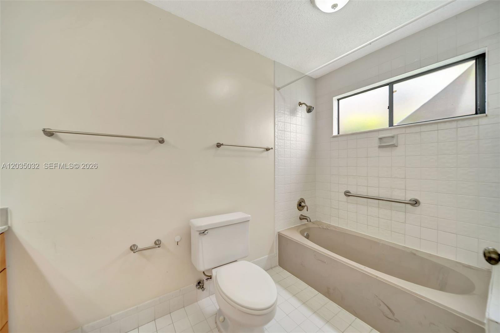 5223 Gate Lake Road, Unit 5223 Tamarac, FL 33319 - Photo 26 of 37 a bathroom with a toilet and a bathtub