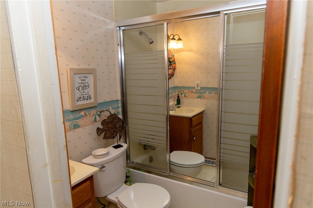 5467 Chapel Road Madison, OH 44057 - Photo 15 of 50 Full bathroom featuring a white tub, sliding glass shower doors, and a vanity with a white basin sink and wood-finish cabinetry