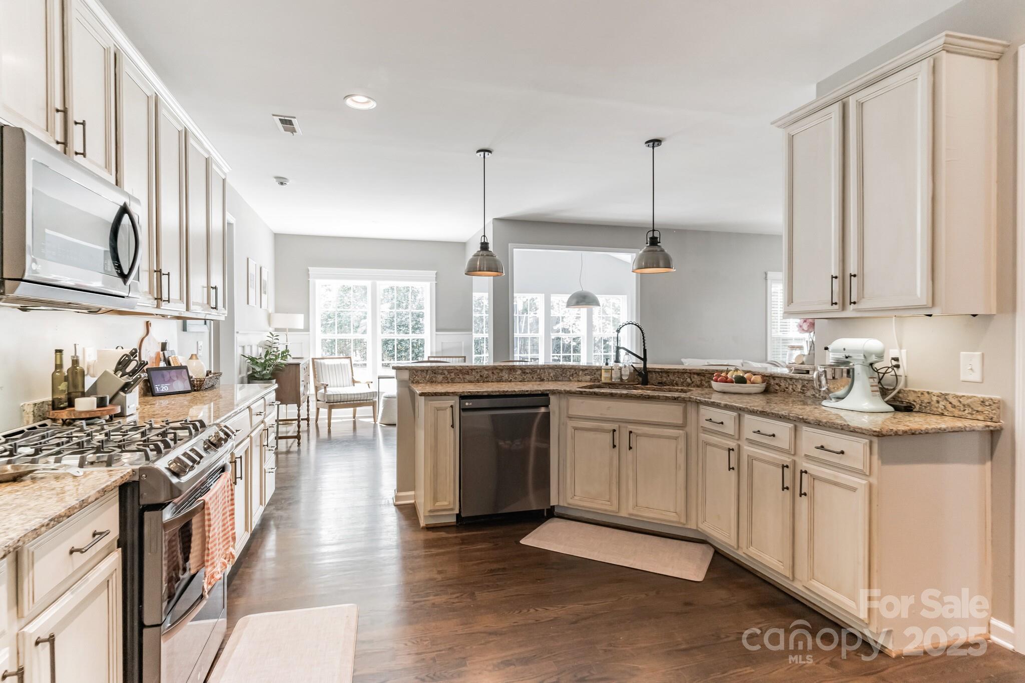 7215 Meyer Road Fort Mill, SC 29715 - Photo 13 of 35 a kitchen with stainless steel appliances granite countertop a stove top oven a sink dishwasher and cabinets with wooden floor