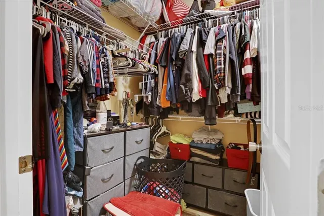 a view of walk in closet with clothes and shoes