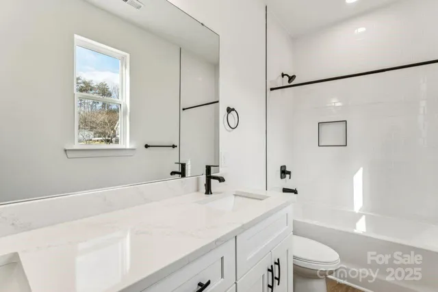 a bathroom with a sink a toilet and a large mirror