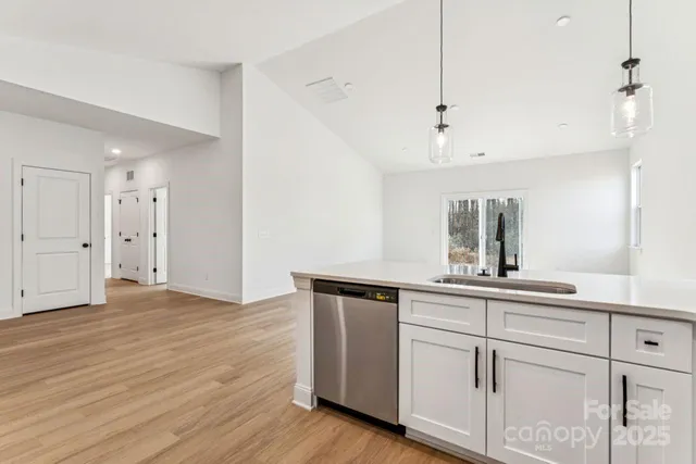 a kitchen with white cabinets and sink