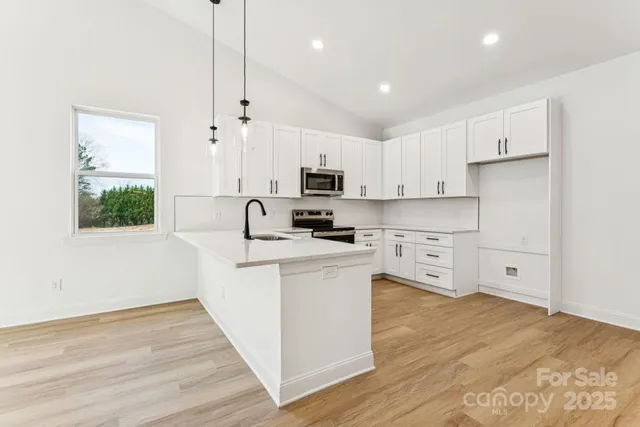 a kitchen with stainless steel appliances granite countertop a stove a sink and a refrigerator