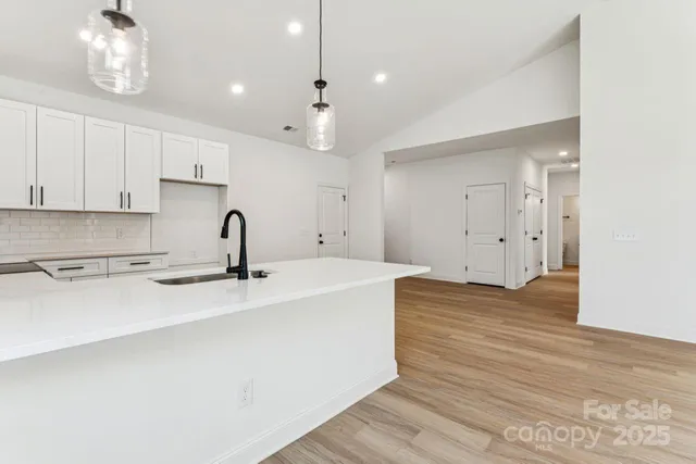 a view of a kitchen with kitchen island a sink stainless steel appliances and cabinets