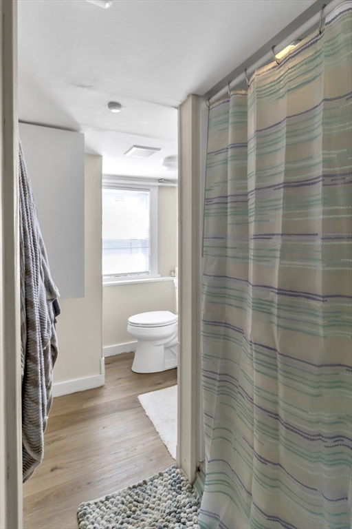 52 H Street Hull, MA 02045 - Photo 25 of 41 a bathroom with a toilet and a shower curtain
