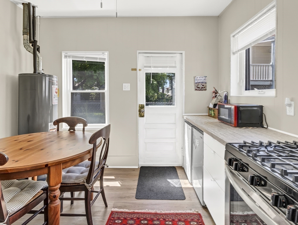 52 H Street Hull, MA 02045 - Photo 30 of 41 a kitchen with stainless steel appliances granite countertop a stove top oven a sink a dining table and chairs