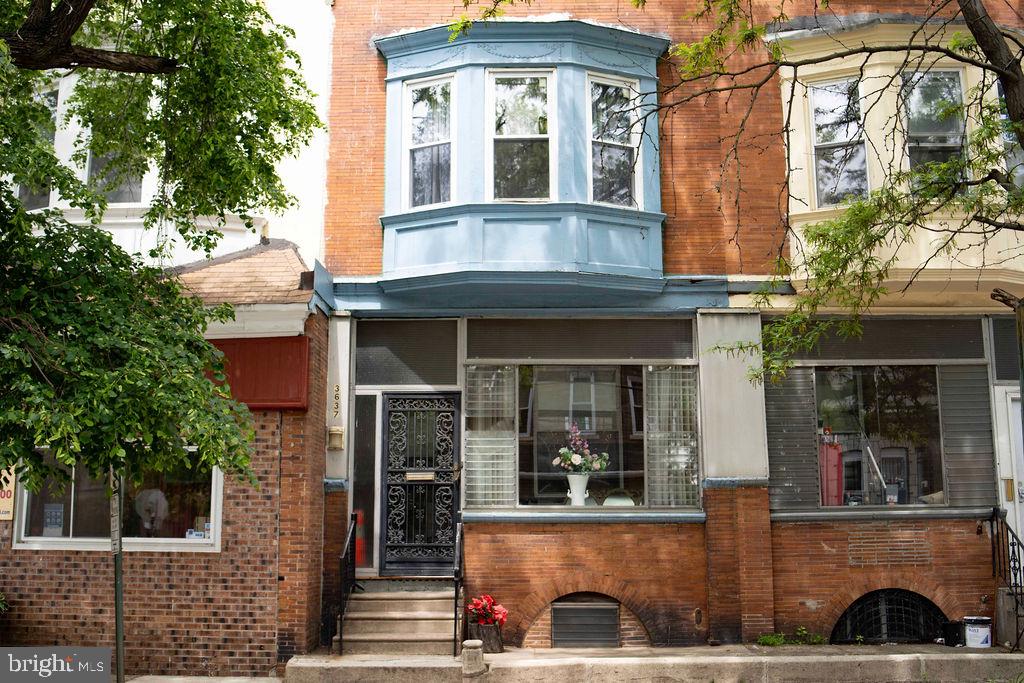 a view of a brick house with windows and plants