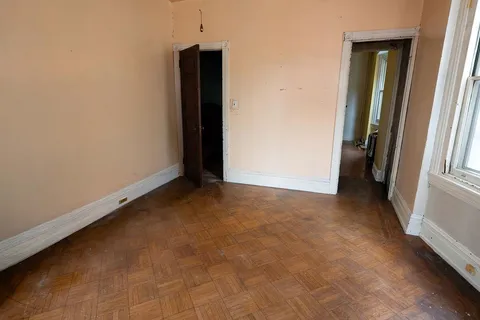 a view of empty room with wooden floor