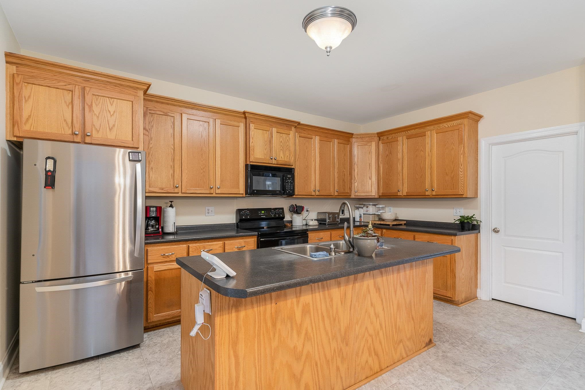 33 Alfred Court Raleigh, NC 27603 - Photo 6 of 24 a kitchen with stainless steel appliances granite countertop a refrigerator a sink a stove and white cabinets