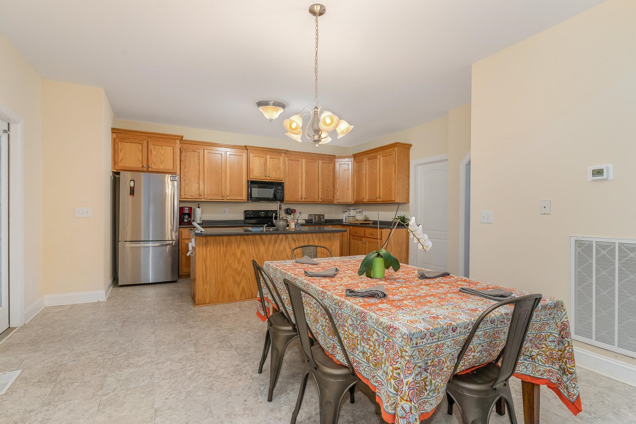 33 Alfred Court Raleigh, NC 27603 - Photo 7 of 24 a kitchen with refrigerator a stove and a chandelier