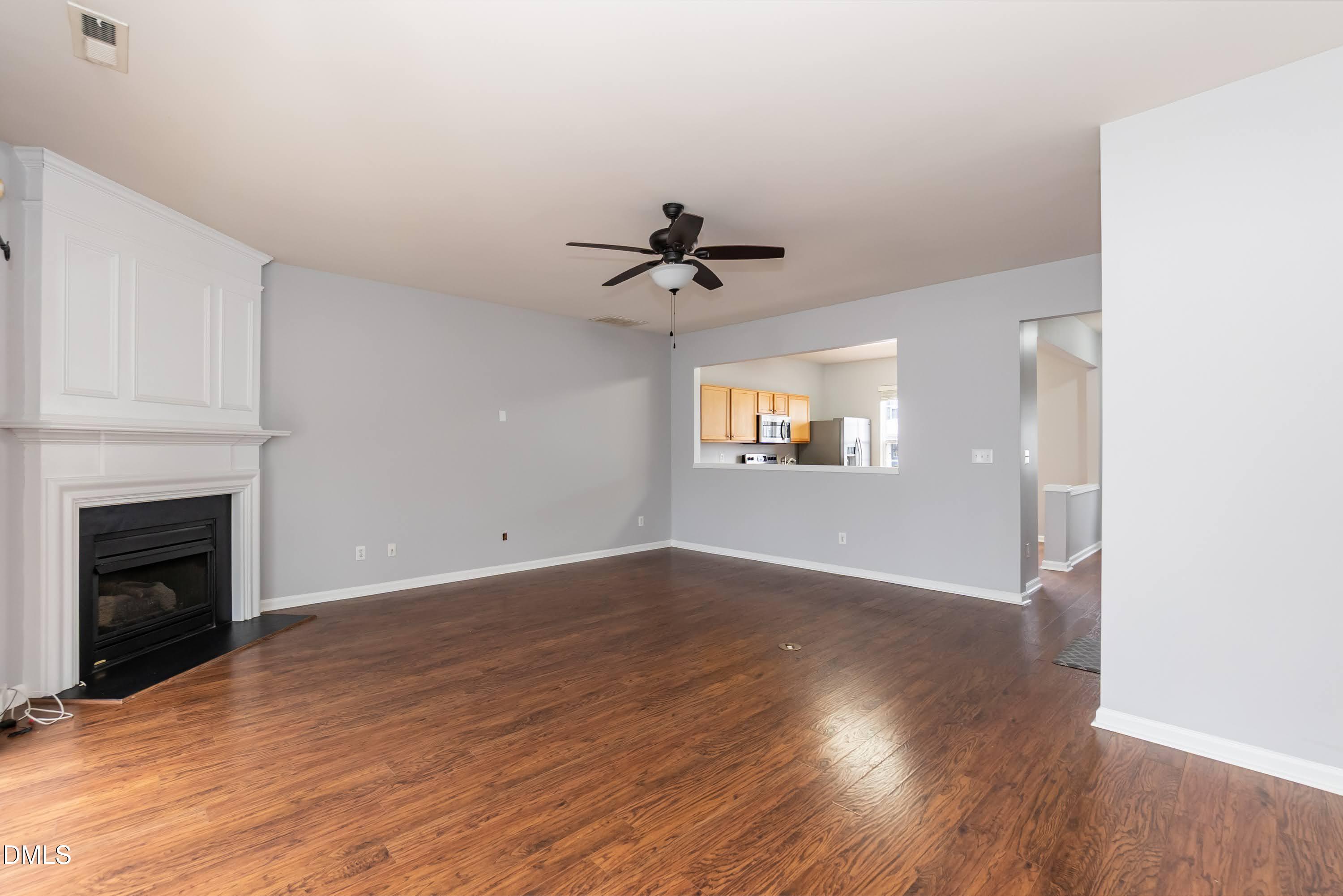 5141 TwelvePole Drive Raleigh, NC 27616 - Photo 13 of 40 an empty room with wooden floor fireplace and windows
