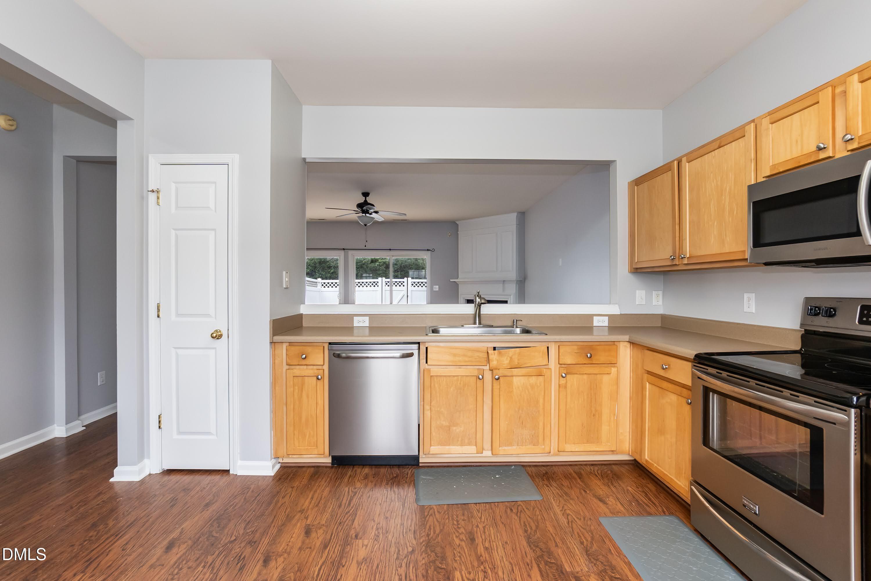 5141 TwelvePole Drive Raleigh, NC 27616 - Photo 18 of 40 a kitchen with stainless steel appliances granite countertop a stove top oven a sink dishwasher and white cabinets with wooden floor