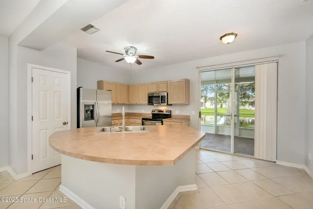 a view of kitchen with sink refrigerator and natural light