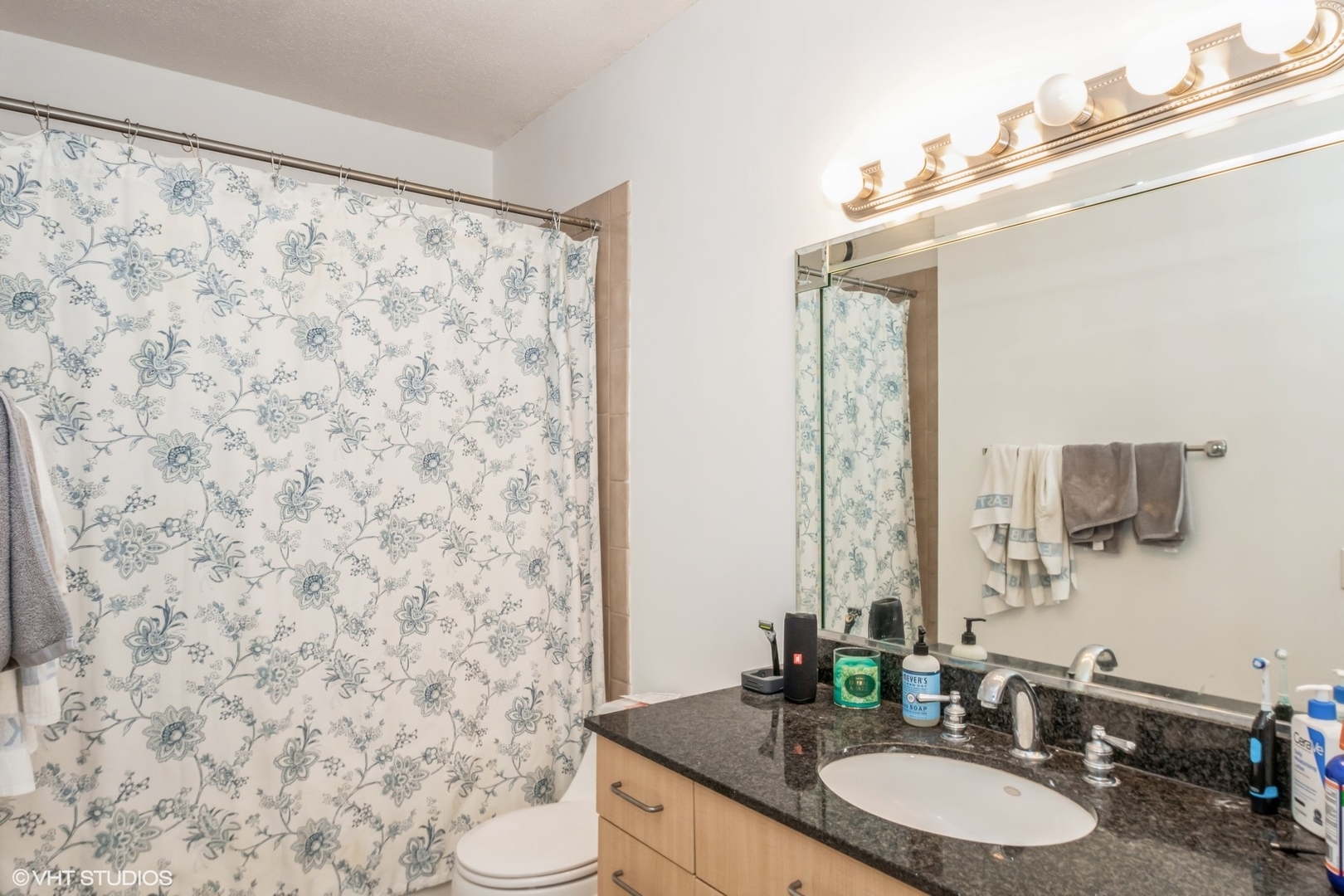 Undisclosed Address Chicago, IL 60611 - Photo 9 of 15 a bathroom with a granite countertop sink a toilet and a mirror