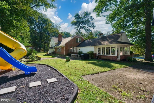 an aerial view of residential house with outdoor space and trees all around