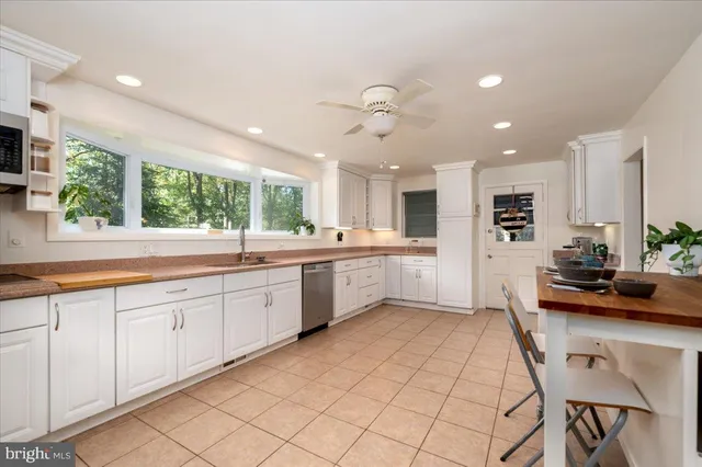 a kitchen with stainless steel appliances white cabinets and a stove top oven