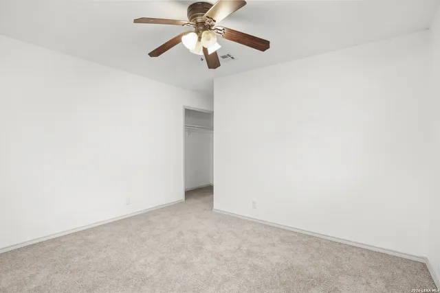 an empty room with a fan and a fan