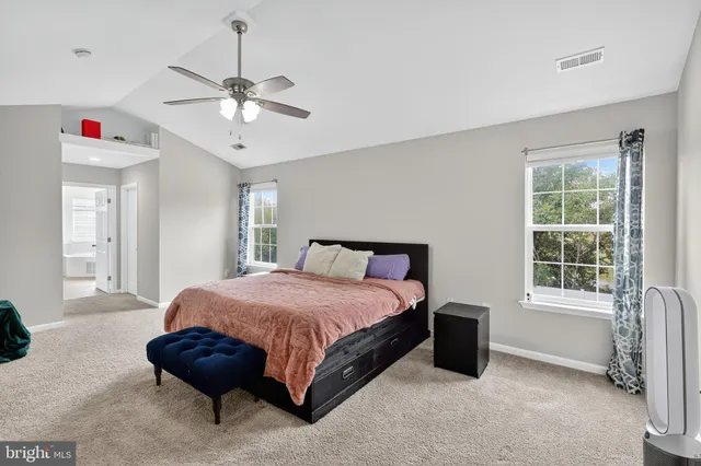a spacious bedroom with a bed and a chandelier