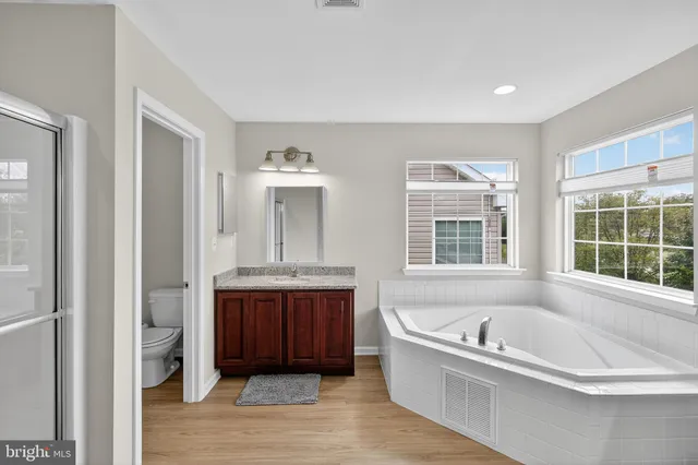 a bathroom with a tub a sink and a window