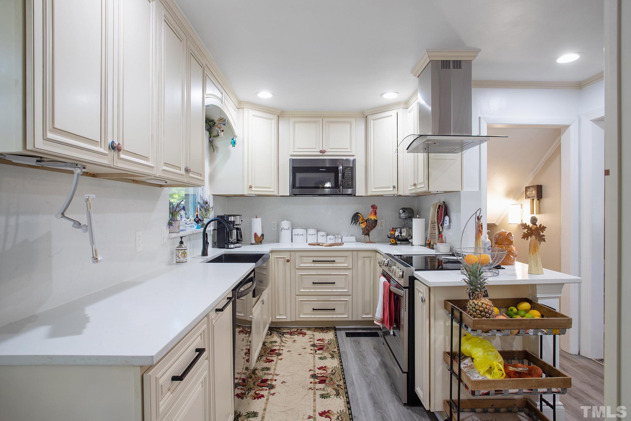 4719 Forestdale Road Raleigh, NC 27603 - Photo 13 of 28 a kitchen with a sink a stove and cabinets