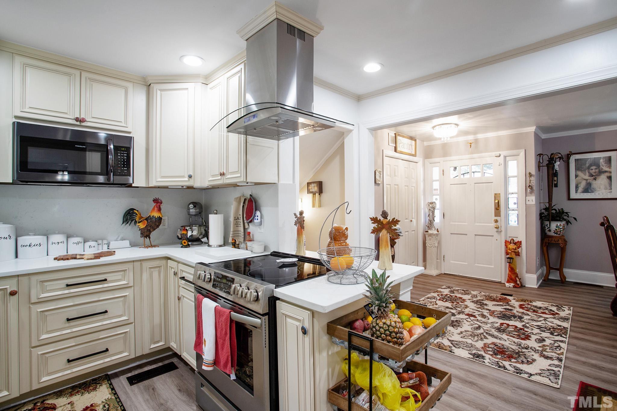 4719 Forestdale Road Raleigh, NC 27603 - Photo 14 of 28 a kitchen with stainless steel appliances granite countertop a stove and cabinets