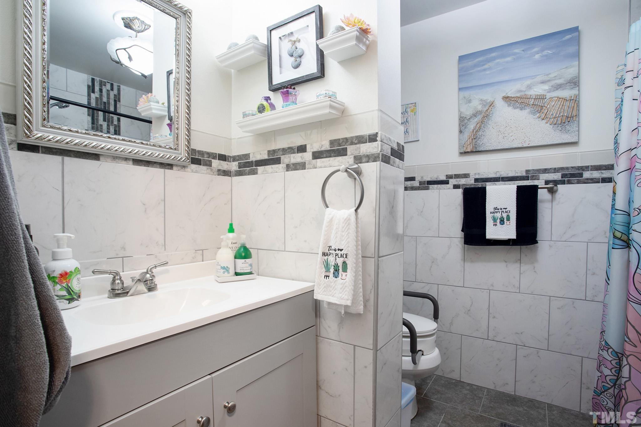 4719 Forestdale Road Raleigh, NC 27603 - Photo 25 of 28 a bathroom with a sink mirror and vanity