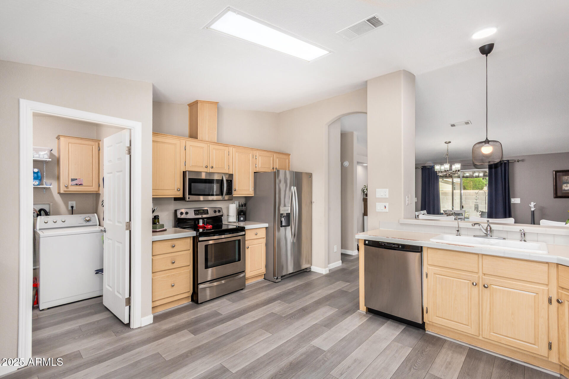 3301 South Goldfield Road, Unit 1002 Apache Junction, AZ 85119 - Photo 9 of 25 a kitchen with cabinets wooden floor and stainless steel appliances