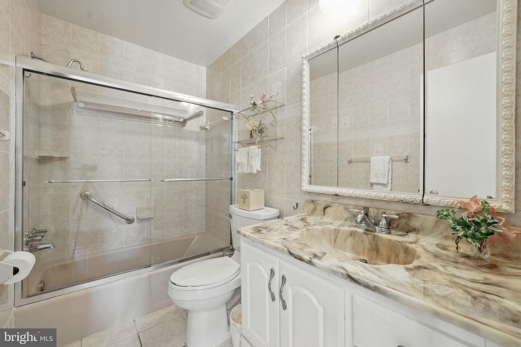 4602 Old Mill Road Alexandria, VA 22309 - Photo 17 of 46 a bathroom with a granite countertop sink toilet and shower