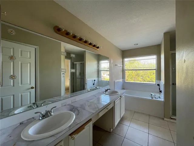 a bathroom with a granite countertop sink and a bathtub