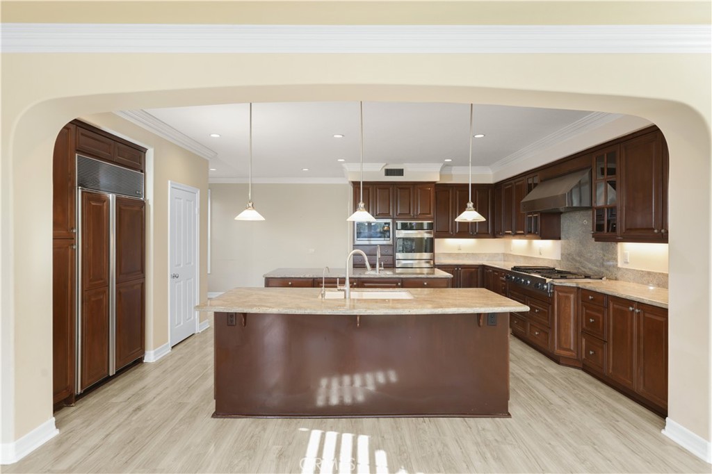 18 Vernon Newport Coast, CA 92657 - Photo 11 of 52 a kitchen with kitchen island a sink a stove and a wooden floors
