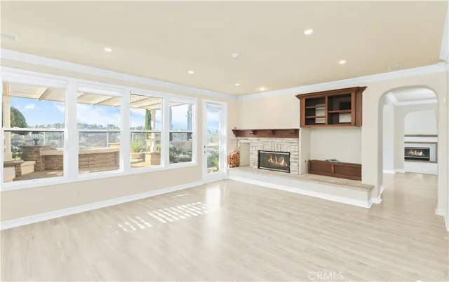 a view of an empty room with a window and fireplace