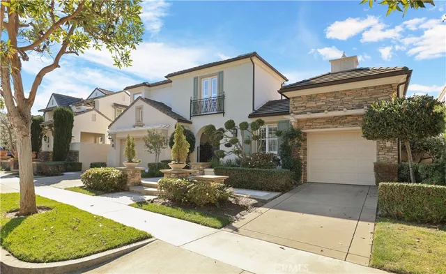 a view of a white house with a small yard and a large tree