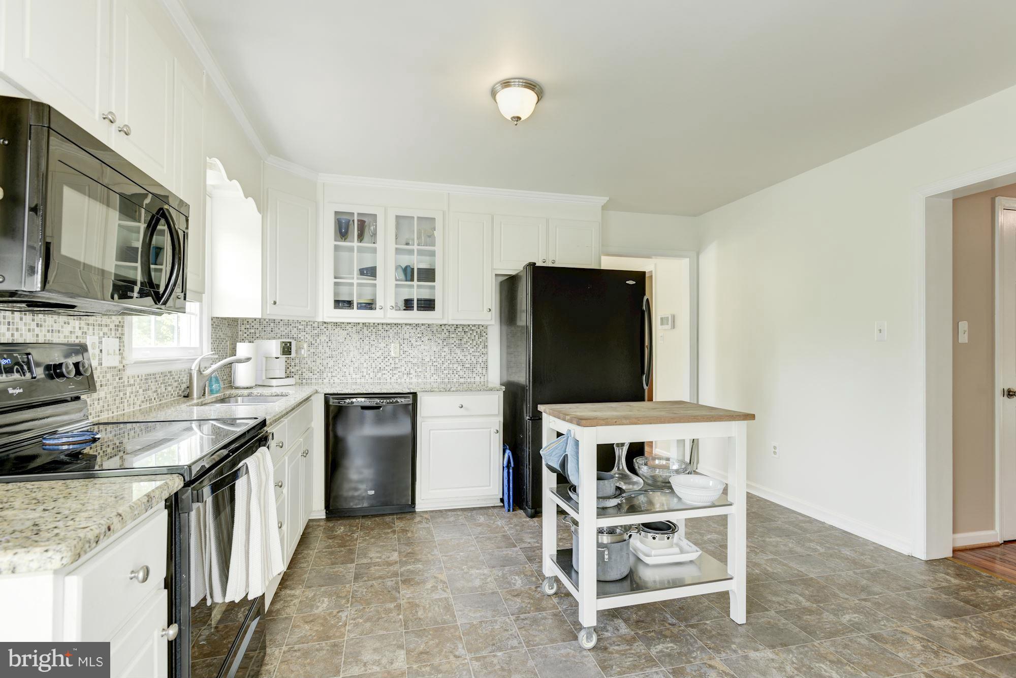 17 New Cut Road Round Hill, VA 20141 - Photo 11 of 29 a kitchen with granite countertop a stove top oven microwave and refrigerator