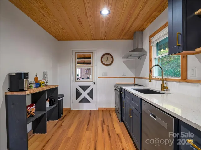 a open kitchen with a sink and wooden floor