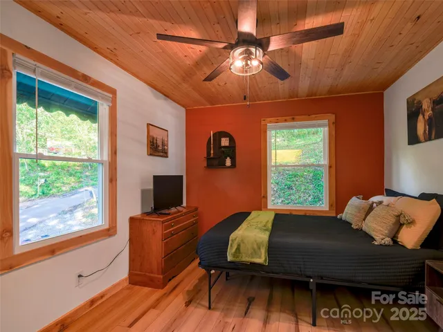 a bedroom with a bed and wooden floor