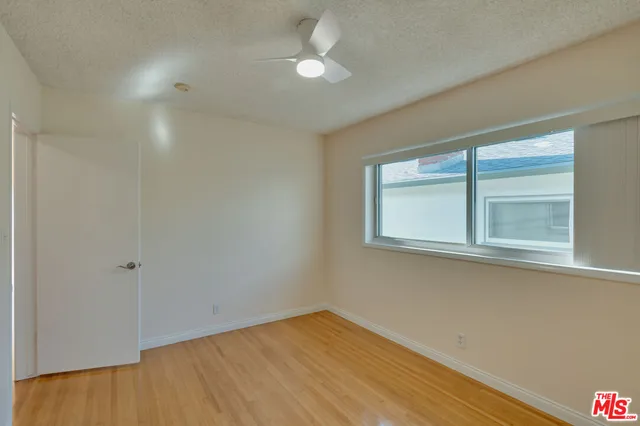 a view of a hallway with front door and wooden floor