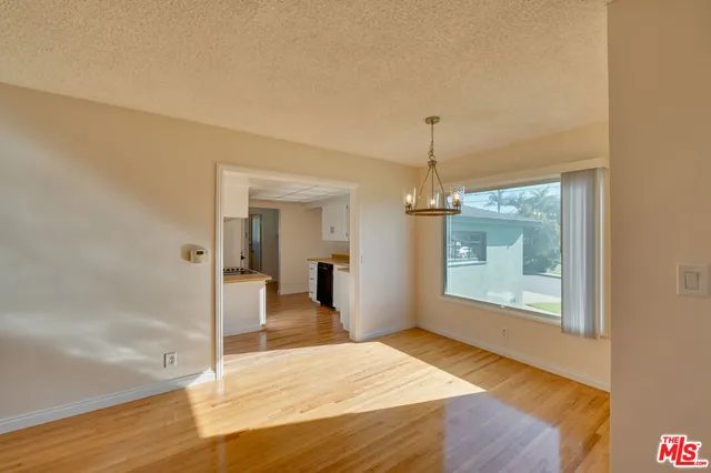 a view of a room with wooden floor fan and windows