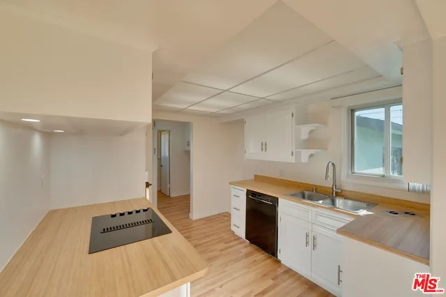 a kitchen with granite countertop a sink and cabinets