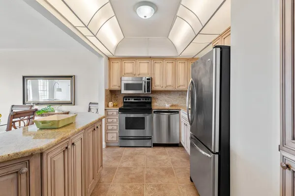 a kitchen with granite countertop a sink stove and cabinets