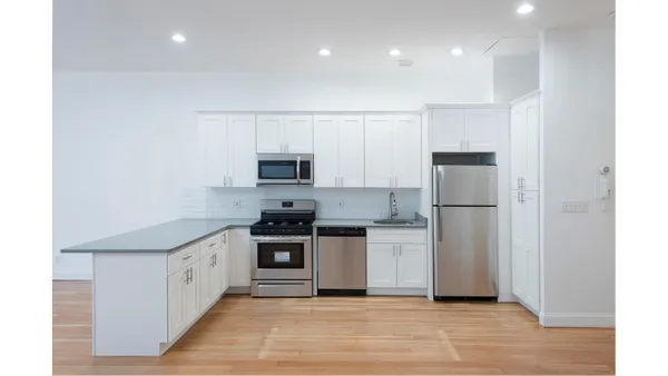 a view of a kitchen with wooden floor and a sink