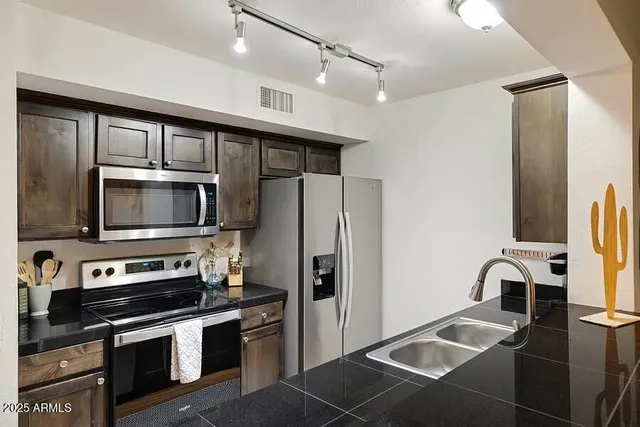 a kitchen with stainless steel appliances granite countertop a refrigerator and a microwave