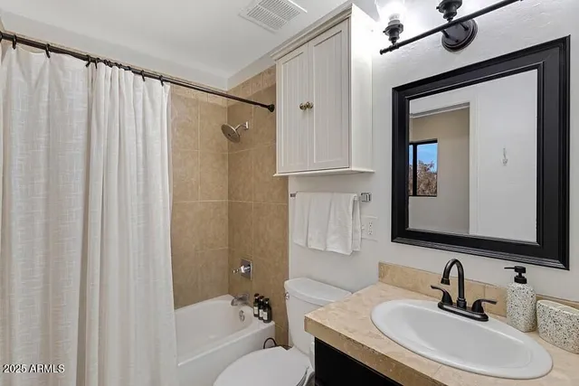 a bedroom with two beds and a flat screen tv