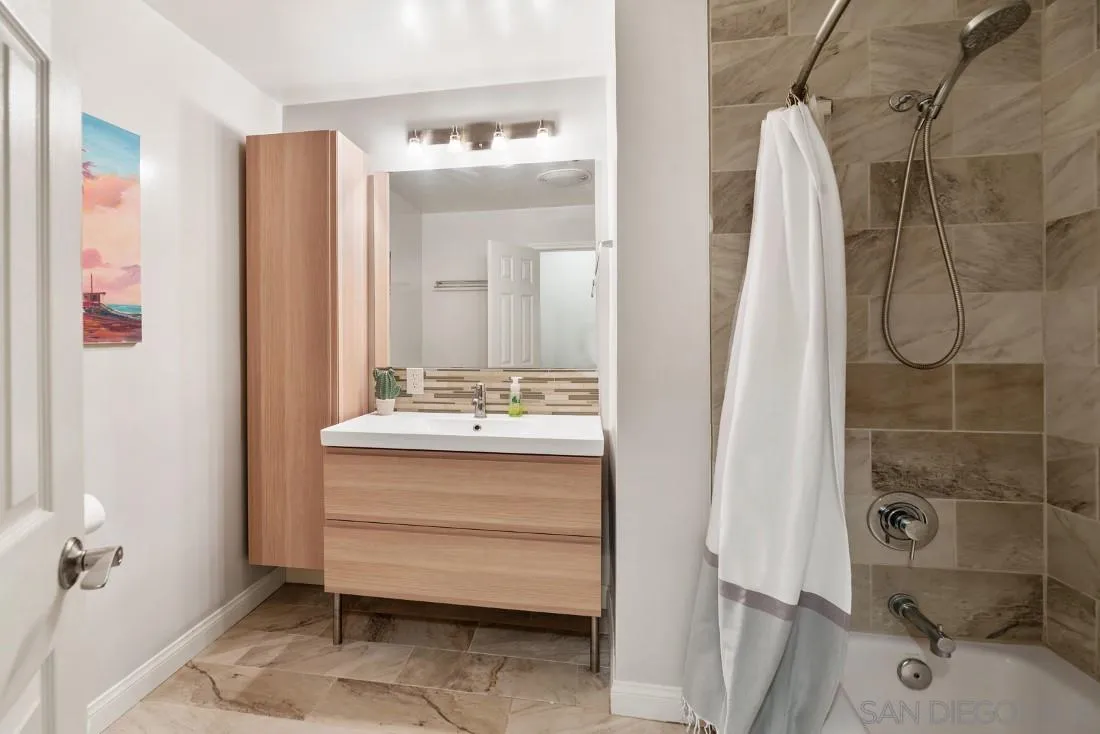 12730 Rios Road San Diego, CA 92128 - Photo 20 of 31 a bathroom with a sink mirror and shower