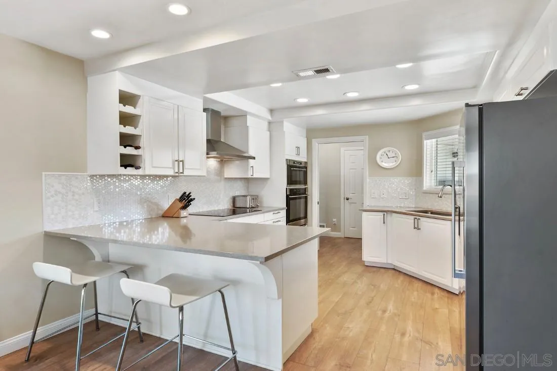 12730 Rios Road San Diego, CA 92128 - Photo 6 of 31 a large white kitchen with lots of counter space and window