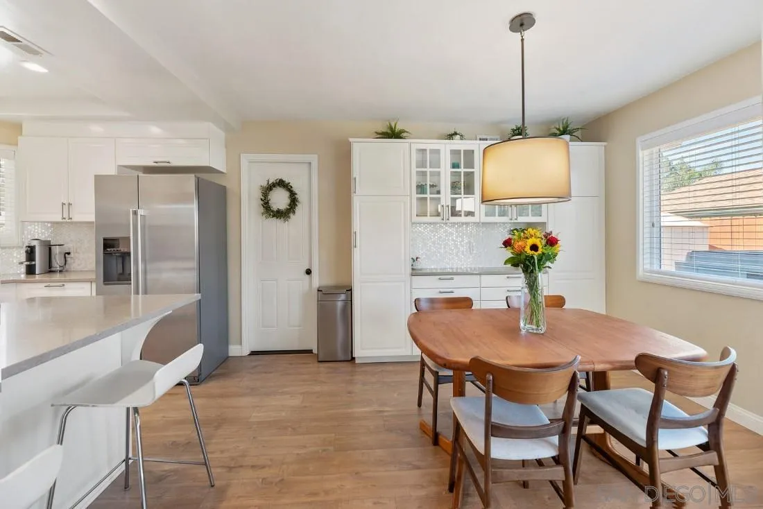 12730 Rios Road San Diego, CA 92128 - Photo 9 of 31 a dining room with furniture a chandelier and wooden floor