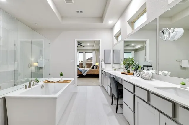a large white bathroom with a double vanity sink and a mirror