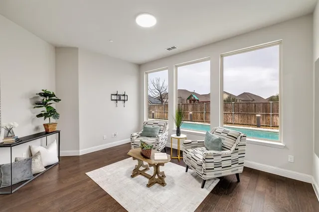 a living room with furniture and a large window with wooden floor