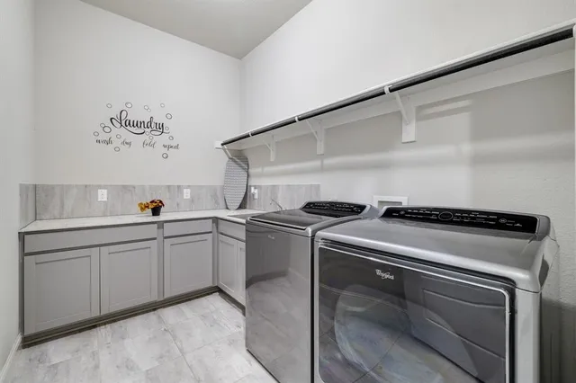 a utility room with sink dryer and washer