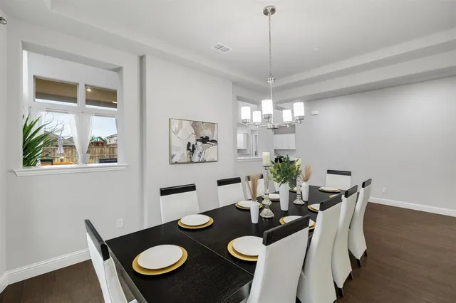 a view of a dining room with furniture a chandelier and wooden floor